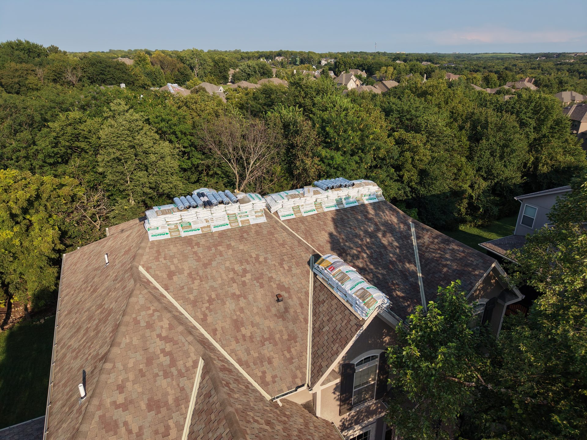 Roofing material bundles staged on a roof before installation